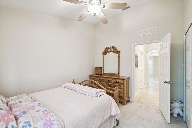 bedroom with visible vents, light carpet, and a ceiling fan