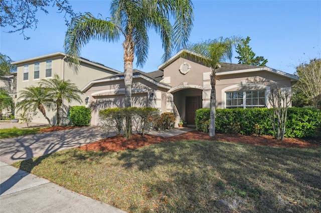 mediterranean / spanish house with stucco siding, driveway, an attached garage, and a front lawn