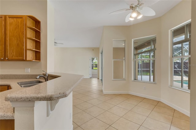 1187 Tadsworth Ter, Lake Mary, FL 32746 - kitchen featuring a sink, ceiling fan, light stone countertops, light tile patterned flooring, and open shelves