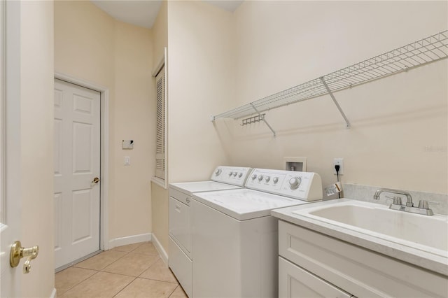1187 Tadsworth Ter, Lake Mary, FL 32746 - washroom featuring independent washer and dryer, a sink, cabinet space, light tile patterned flooring, and baseboards