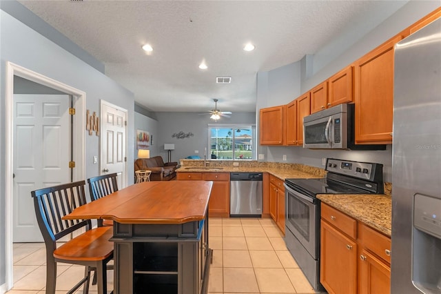 kitchen with light tile patterned floors, visible vents, appliances with stainless steel finishes, and a sink