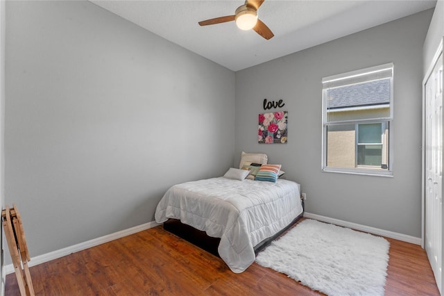 bedroom featuring ceiling fan, baseboards, and wood finished floors