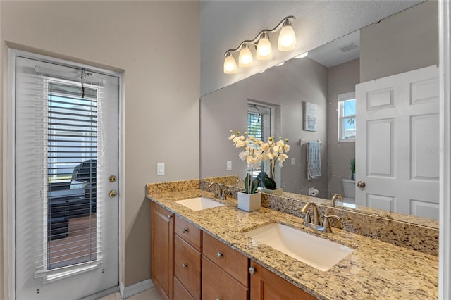 bathroom featuring a sink, toilet, and double vanity