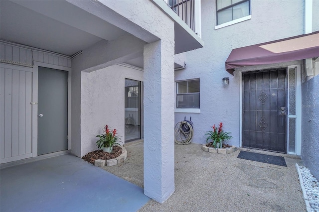 entrance to property featuring stucco siding