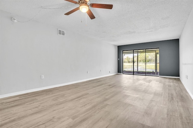 unfurnished room with visible vents, ceiling fan, baseboards, light wood-type flooring, and a textured ceiling