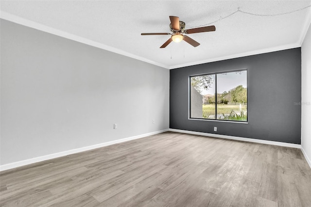 spare room featuring ornamental molding, a textured ceiling, wood finished floors, baseboards, and ceiling fan