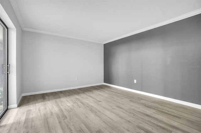 spare room with baseboards, a textured ceiling, wood finished floors, and ornamental molding