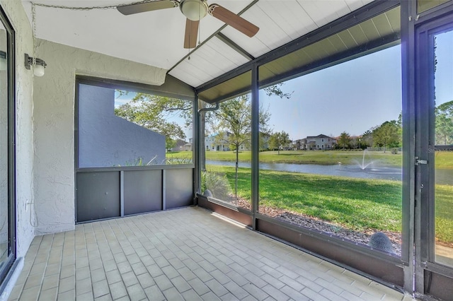 unfurnished sunroom with ceiling fan, lofted ceiling, and a water view