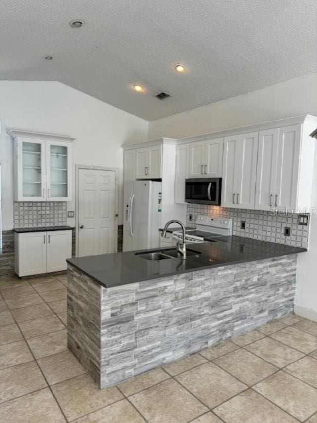 kitchen featuring white appliances, visible vents, a sink, white cabinetry, and dark countertops