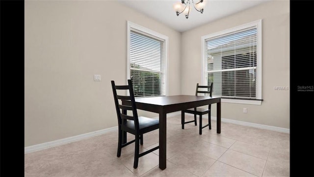 dining area with baseboards, a chandelier, and light tile patterned flooring