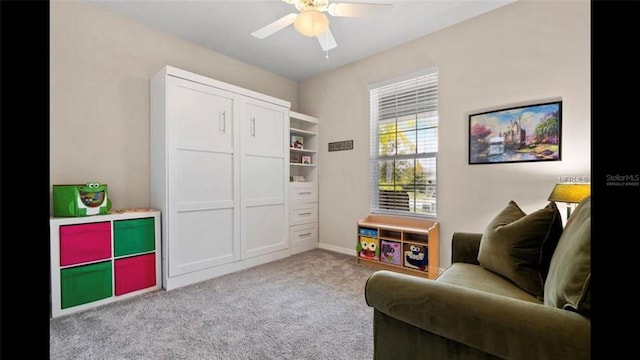 living area with carpet flooring and ceiling fan