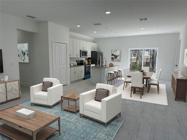 living area featuring recessed lighting, visible vents, and baseboards