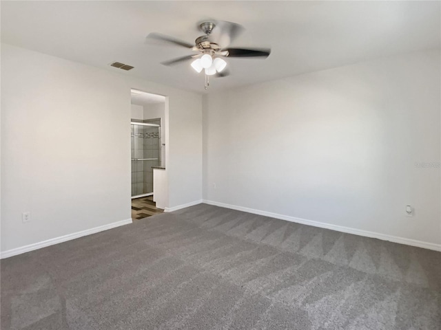 unfurnished bedroom featuring visible vents, dark carpet, baseboards, and ceiling fan