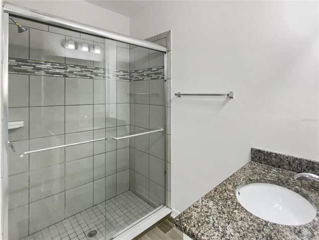 bathroom with a shower stall and a sink