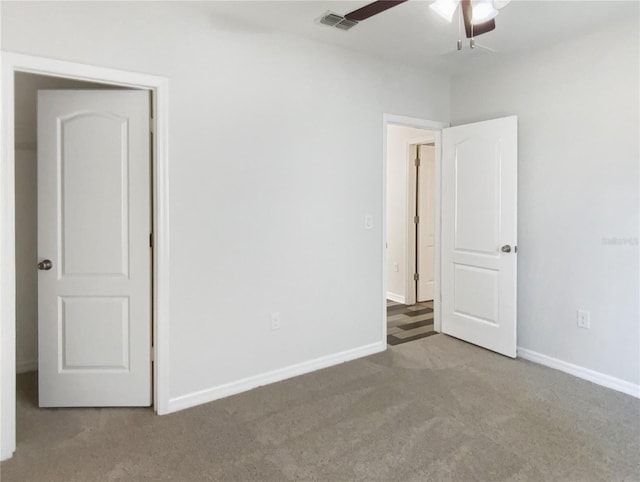 unfurnished bedroom with carpet flooring, baseboards, visible vents, and a ceiling fan