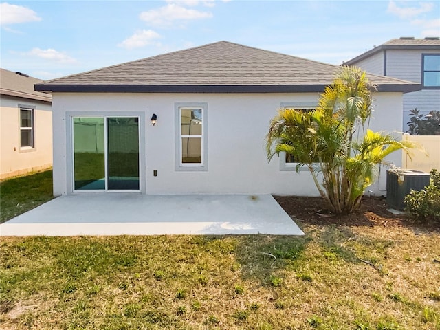 back of property featuring central AC, a lawn, a shingled roof, and a patio