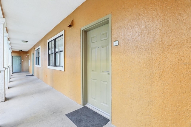 doorway to property featuring stucco siding