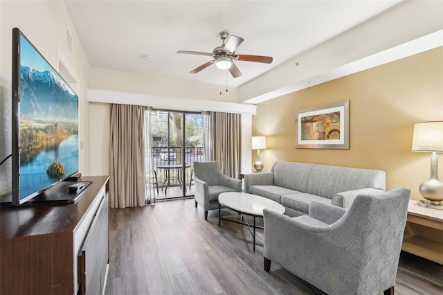 living area featuring visible vents, dark wood-type flooring, and a ceiling fan