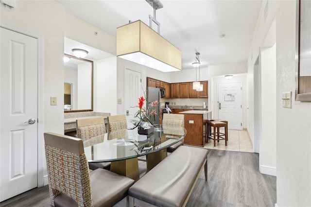 dining area featuring light wood-style floors and visible vents