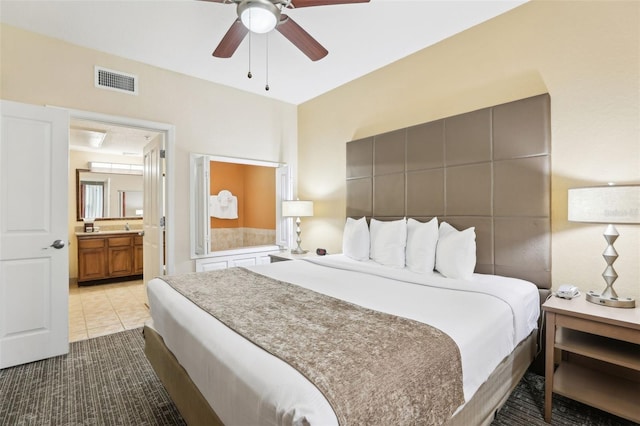 tiled bedroom featuring visible vents, ceiling fan, and ensuite bathroom