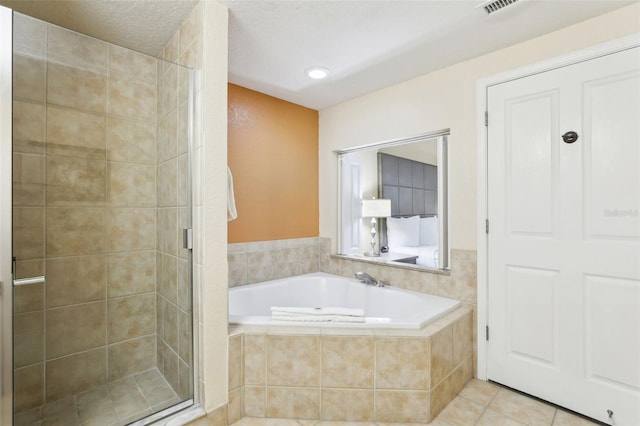 bathroom featuring tile patterned floors, a shower stall, a textured ceiling, and a garden tub