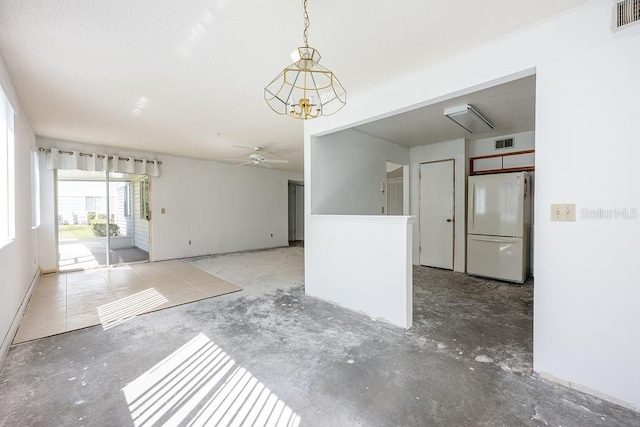 unfurnished room with ceiling fan with notable chandelier and visible vents