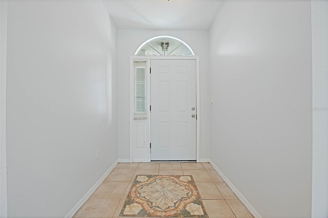 doorway to outside featuring light tile patterned floors and baseboards