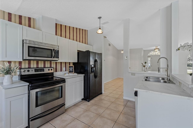 kitchen featuring visible vents, wallpapered walls, white cabinets, stainless steel appliances, and a sink