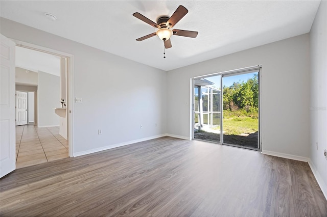 empty room featuring baseboards, wood finished floors, and a ceiling fan