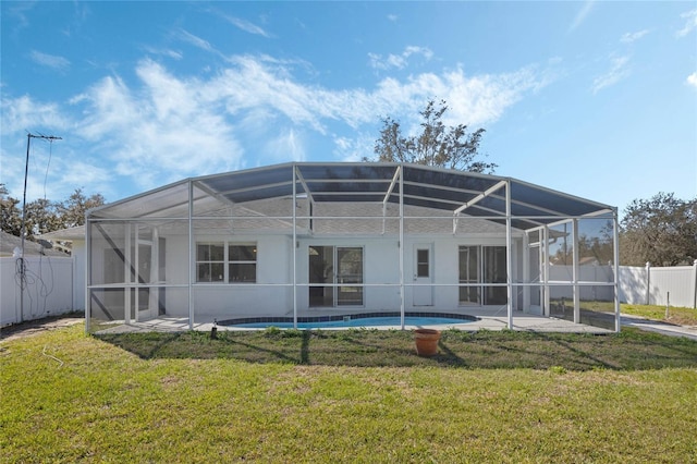 rear view of house featuring glass enclosure, a patio, a yard, and a fenced backyard