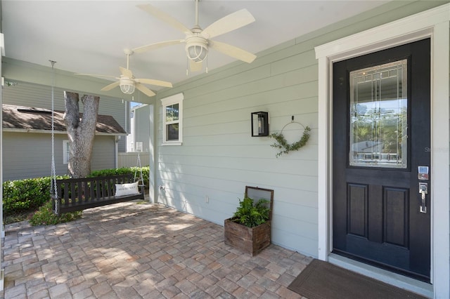 doorway to property featuring a porch and ceiling fan