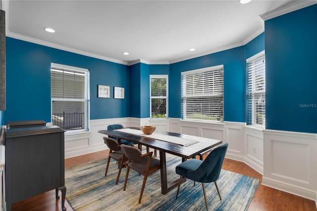 dining room featuring recessed lighting, wood finished floors, a wainscoted wall, and ornamental molding