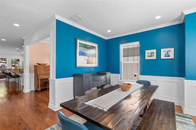 dining space with visible vents, wainscoting, and wood finished floors