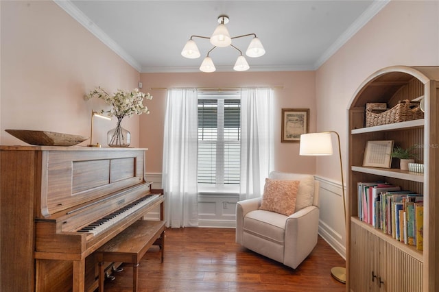 sitting room with an inviting chandelier, wood finished floors, a wainscoted wall, and ornamental molding