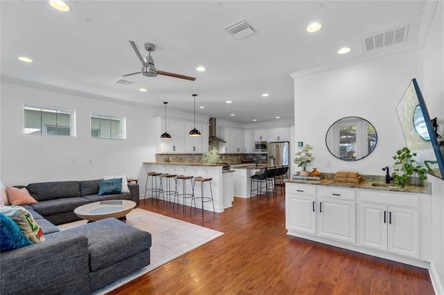 living room featuring ceiling fan, visible vents, and dark wood-style floors