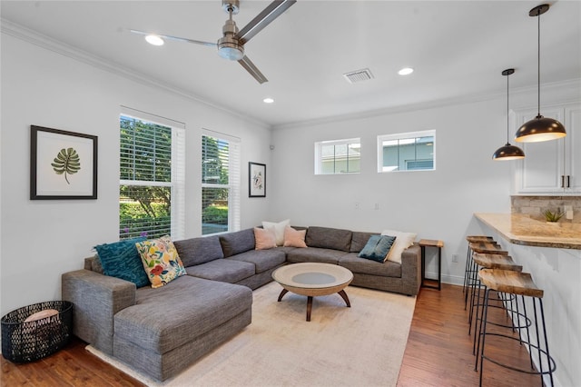 living area featuring visible vents, crown molding, recessed lighting, wood finished floors, and a ceiling fan