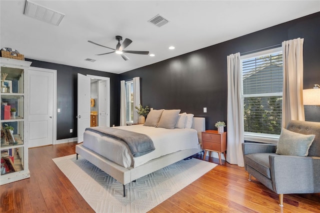 bedroom with light wood-type flooring, visible vents, and baseboards