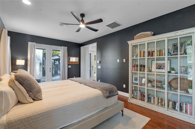 bedroom with access to exterior, wood finished floors, visible vents, and baseboards