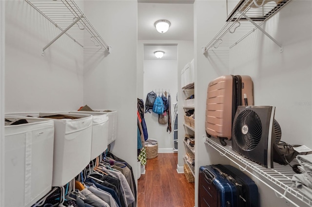 walk in closet with wood finished floors and separate washer and dryer