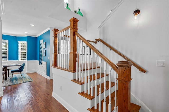 staircase featuring a wainscoted wall, ornamental molding, wood finished floors, recessed lighting, and a decorative wall