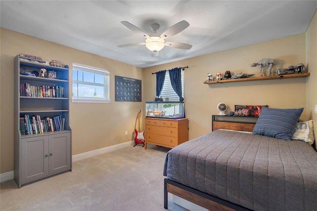 bedroom featuring light colored carpet, baseboards, and ceiling fan