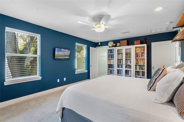 carpeted bedroom featuring multiple windows, visible vents, baseboards, and ceiling fan