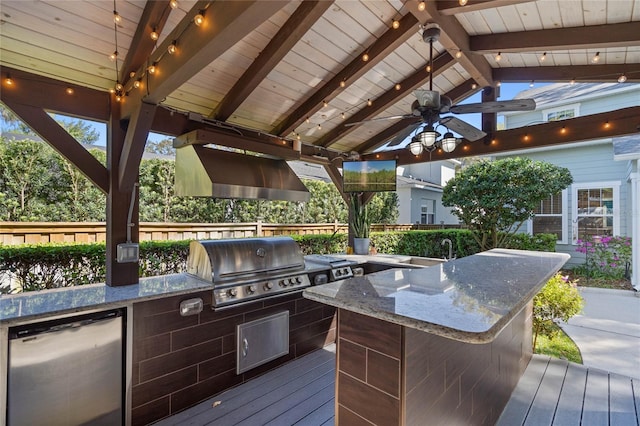 wooden terrace with a ceiling fan, a sink, grilling area, outdoor wet bar, and exterior kitchen