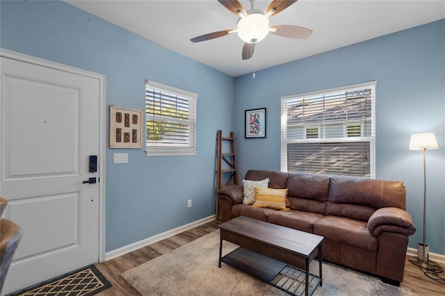 living area with wood finished floors, baseboards, and ceiling fan