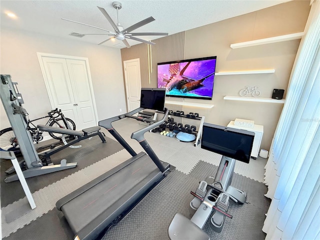 gym featuring visible vents, a textured ceiling, and ceiling fan