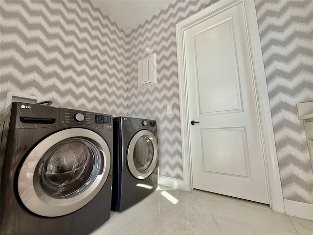 laundry area with marble finish floor, washer and clothes dryer, wallpapered walls, baseboards, and laundry area