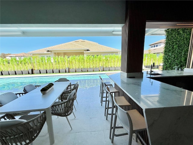 view of patio / terrace with a fenced in pool and an outdoor bar