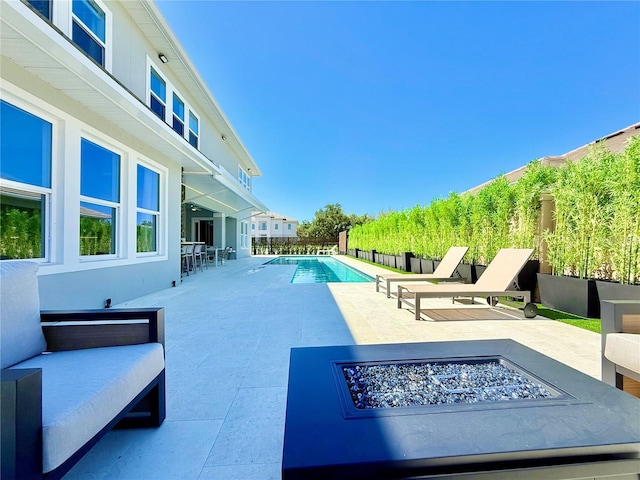 view of swimming pool with a fenced in pool, an outdoor fire pit, a patio, and fence