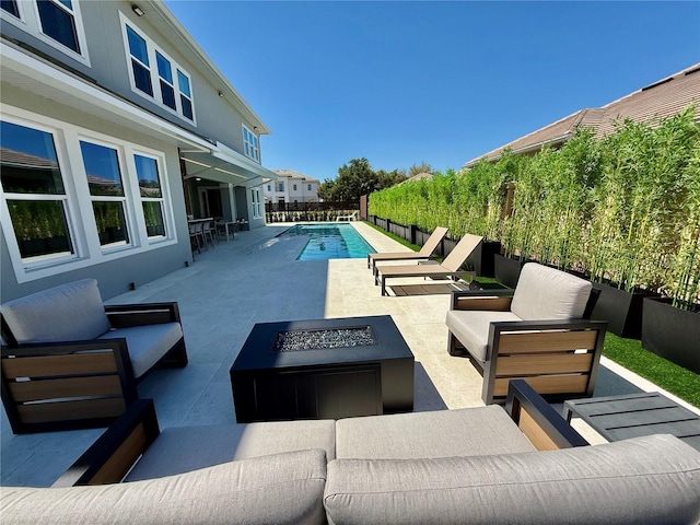 view of pool featuring an outdoor living space with a fire pit, a patio, and a fenced in pool