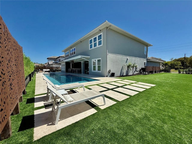 back of house with a fenced in pool, stucco siding, a lawn, a fenced backyard, and a patio area